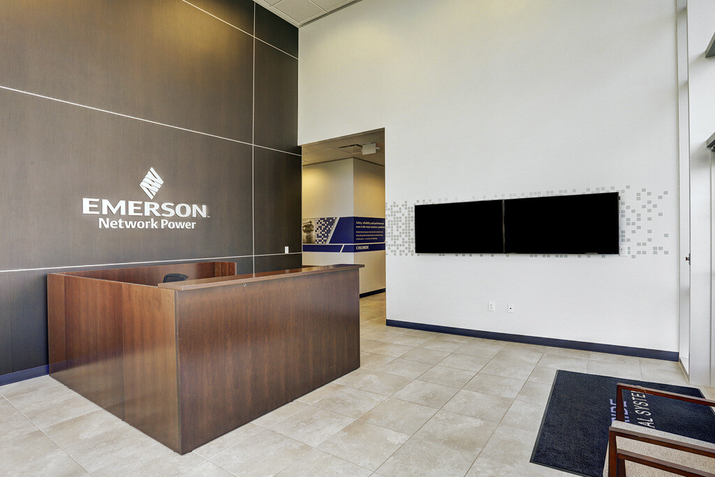 Close-up of Emerson Network Power reception desk and wall logo in a renovated office in Houston, TX