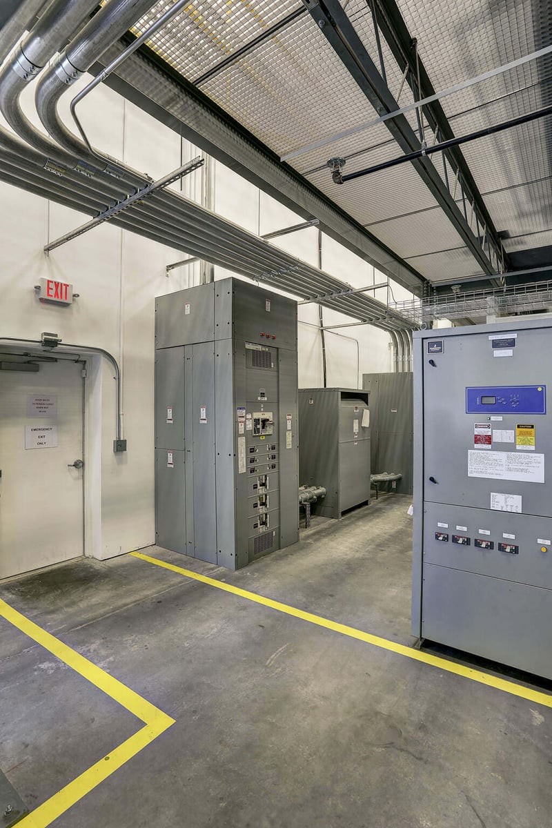 Industrial equipment room in Emerson Network Power’s Houston, TX facility, featuring advanced electrical systems and safety markings