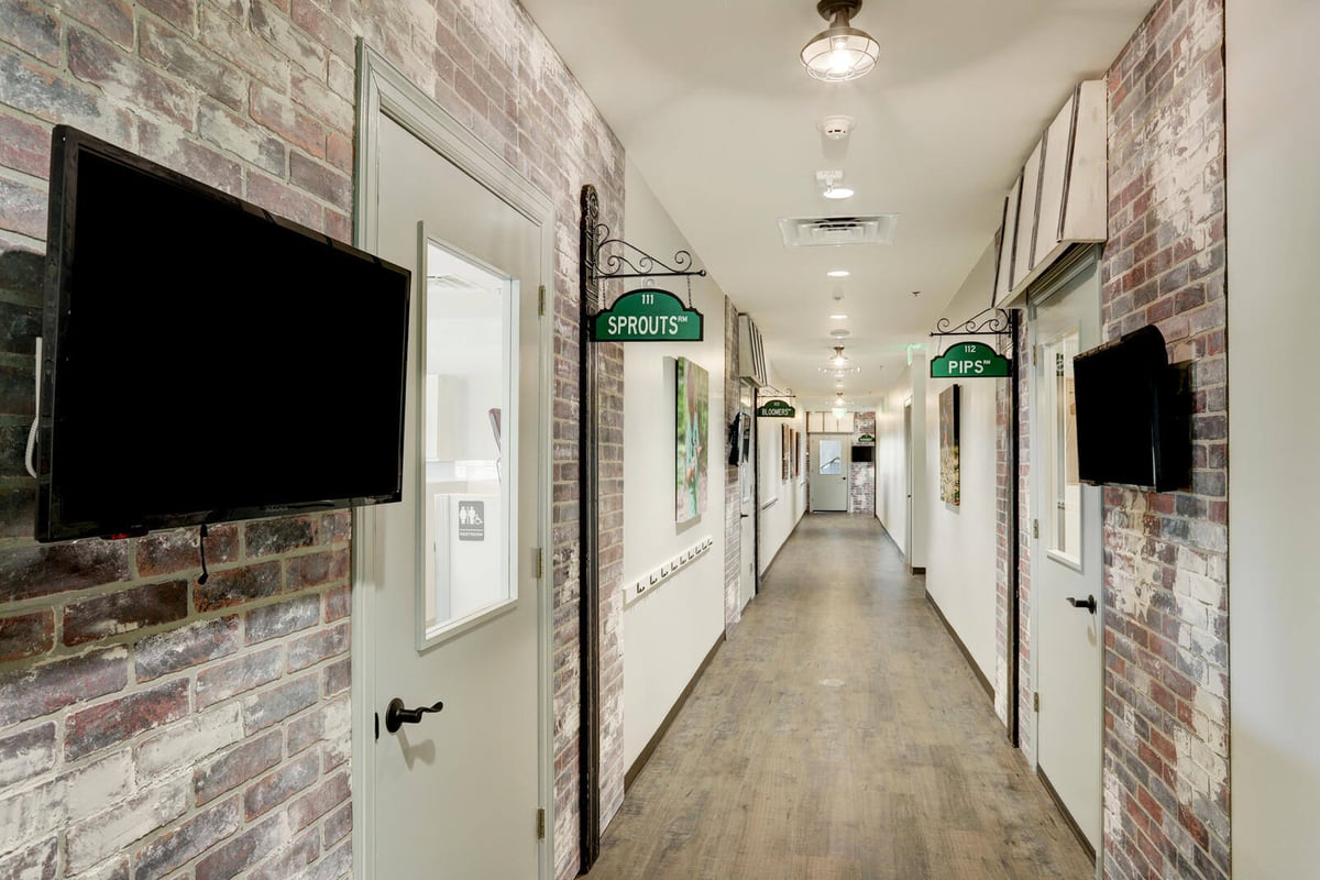 Minimalistic hallway with modern wooden flooring and a door to the reception area by GSD Construction in Houston, TX