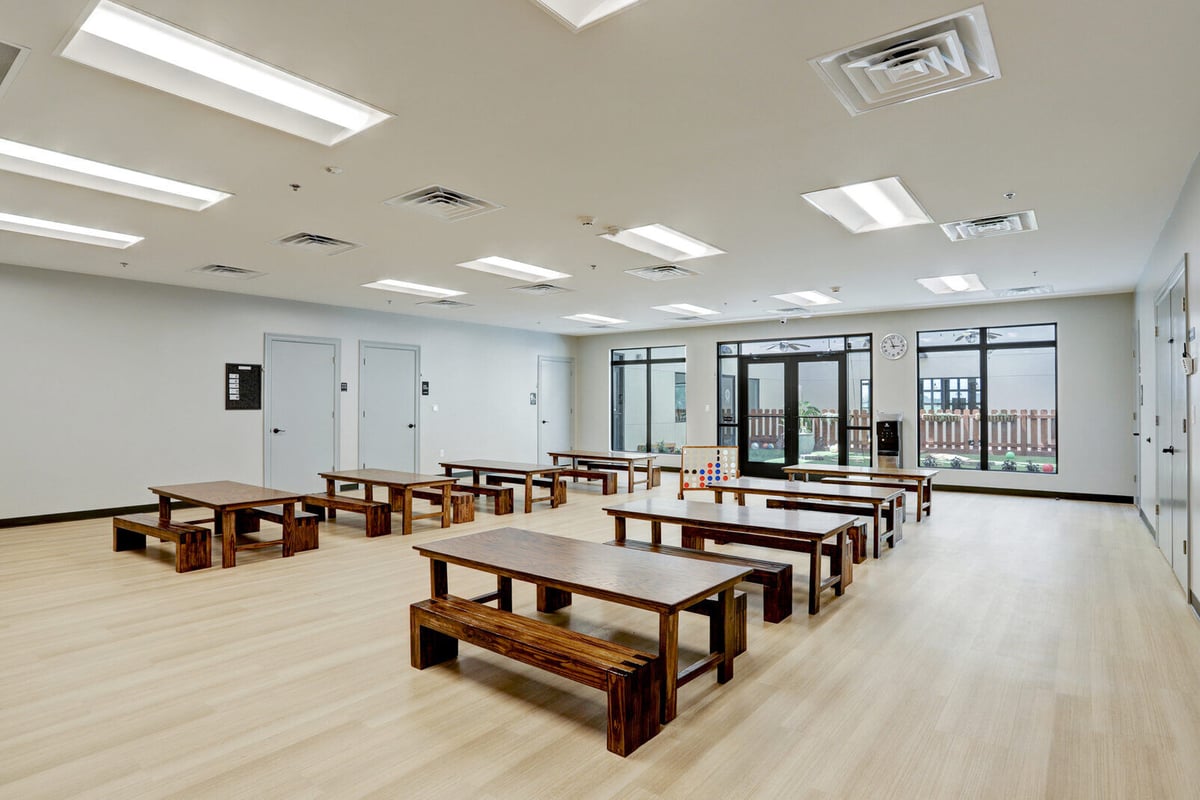 Spacious activity room with wooden tables and benches, part of GSD Construction’s commercial renovation in Houston, TX