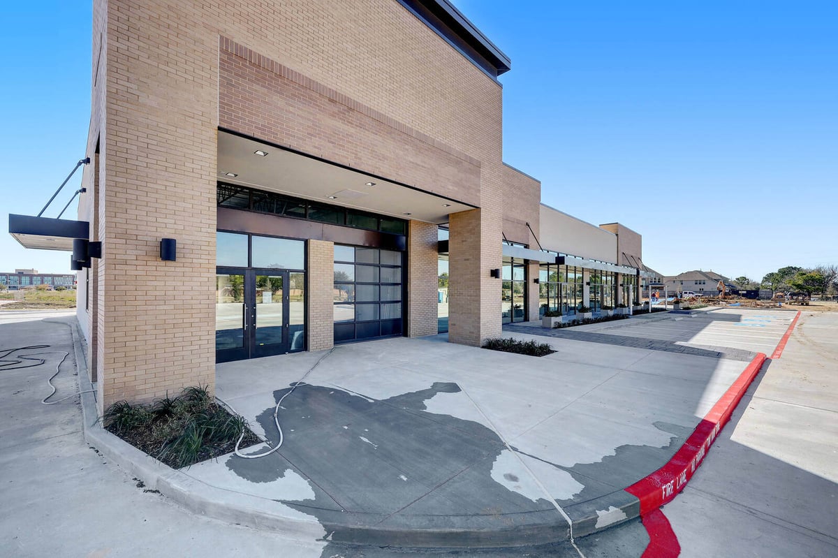 Corner perspective of a newly constructed brick-and-glass commercial building in Houston, TX