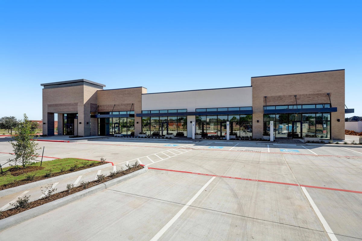 Wide-angle view of a modern commercial development with landscaped surroundings and spacious parking in Houston, TX