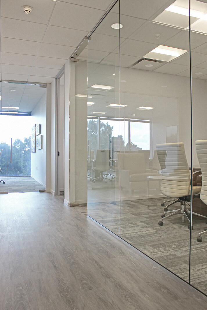 Modern office hallway with glass walls and natural lighting in a GSD Construction commercial renovation in Houston, TX