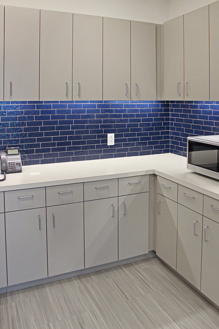Stylish kitchenette with modern gray cabinets and vibrant blue tiles, completed by GSD Construction in Houston, TX